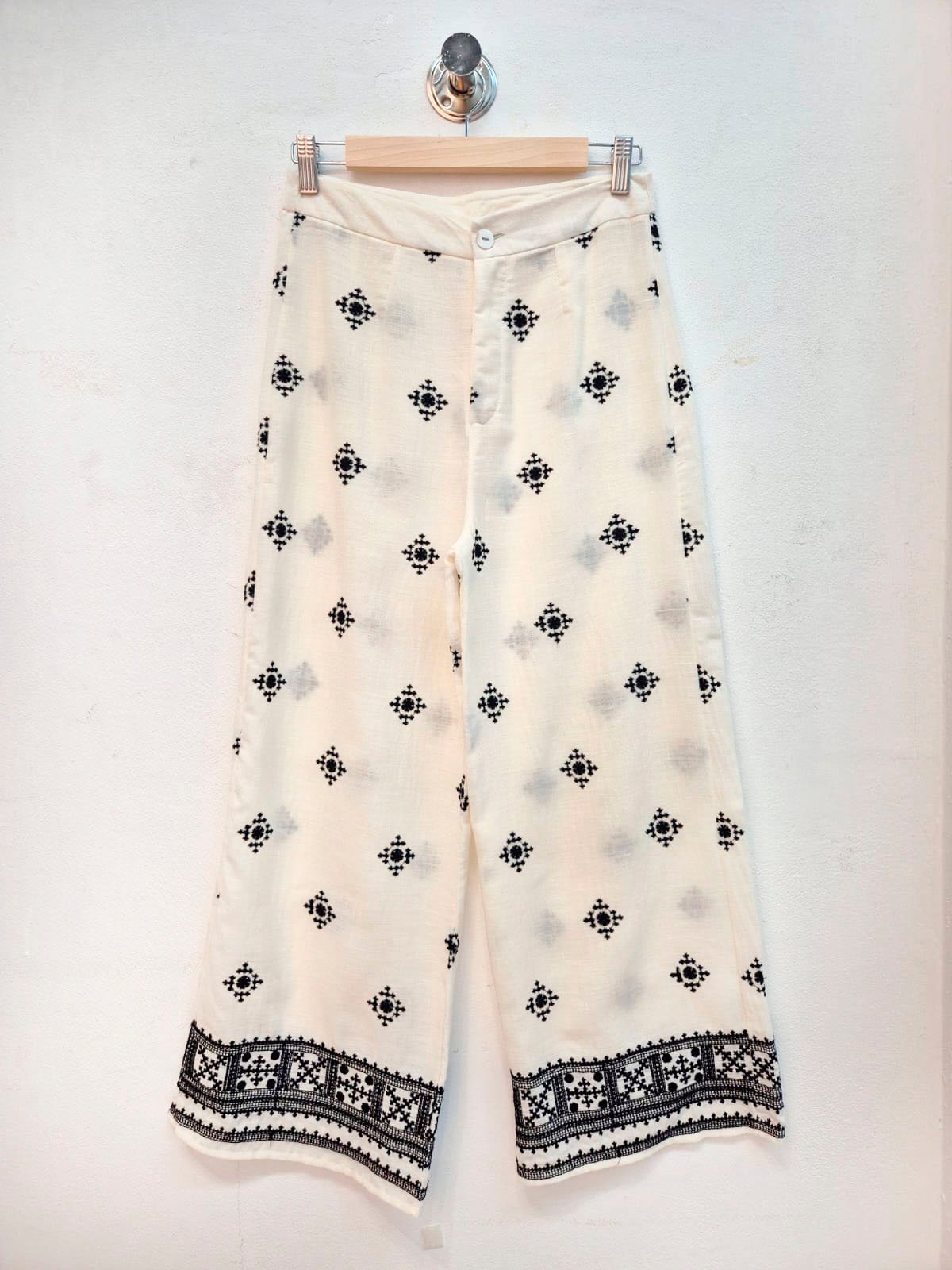 Pantalón crema con estampado geométrico negro y borde tejido en dobladillo