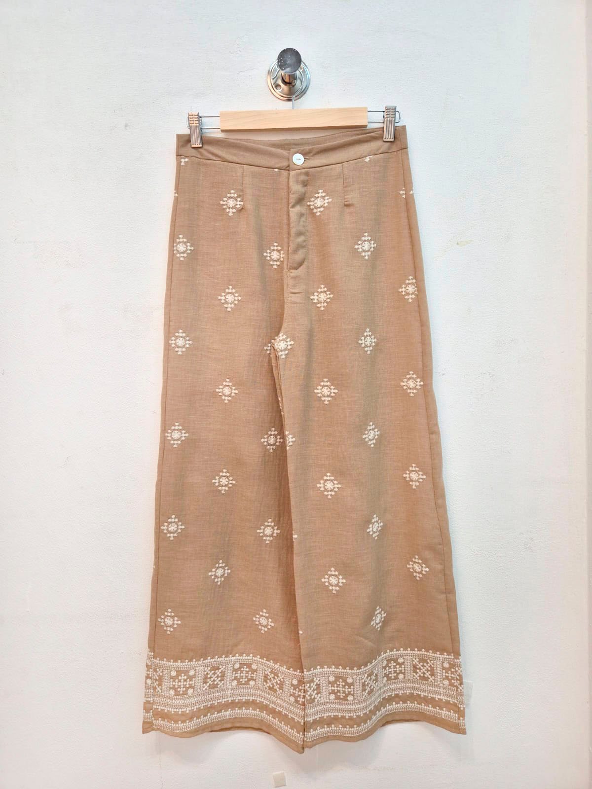 Pantalón beige con bordado blanco geométrico y encaje en ruedo