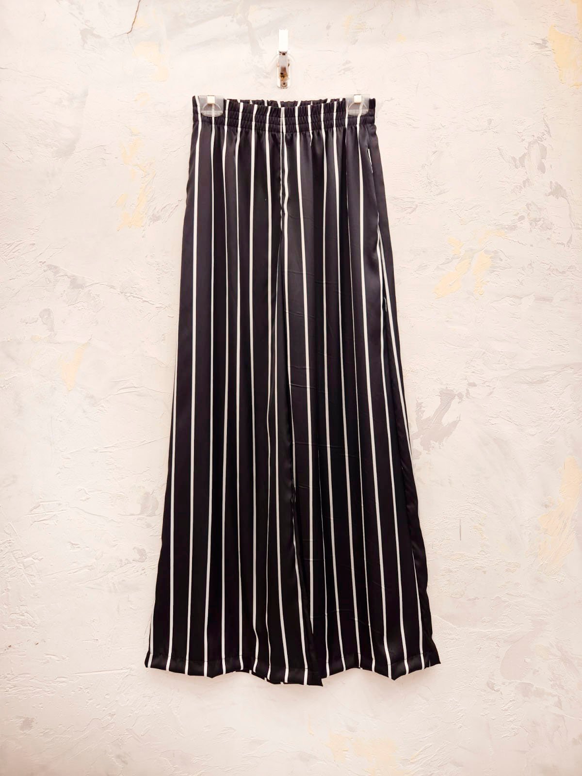 Pantalón palazzo negro con rayas blancas verticales y cintura elástica