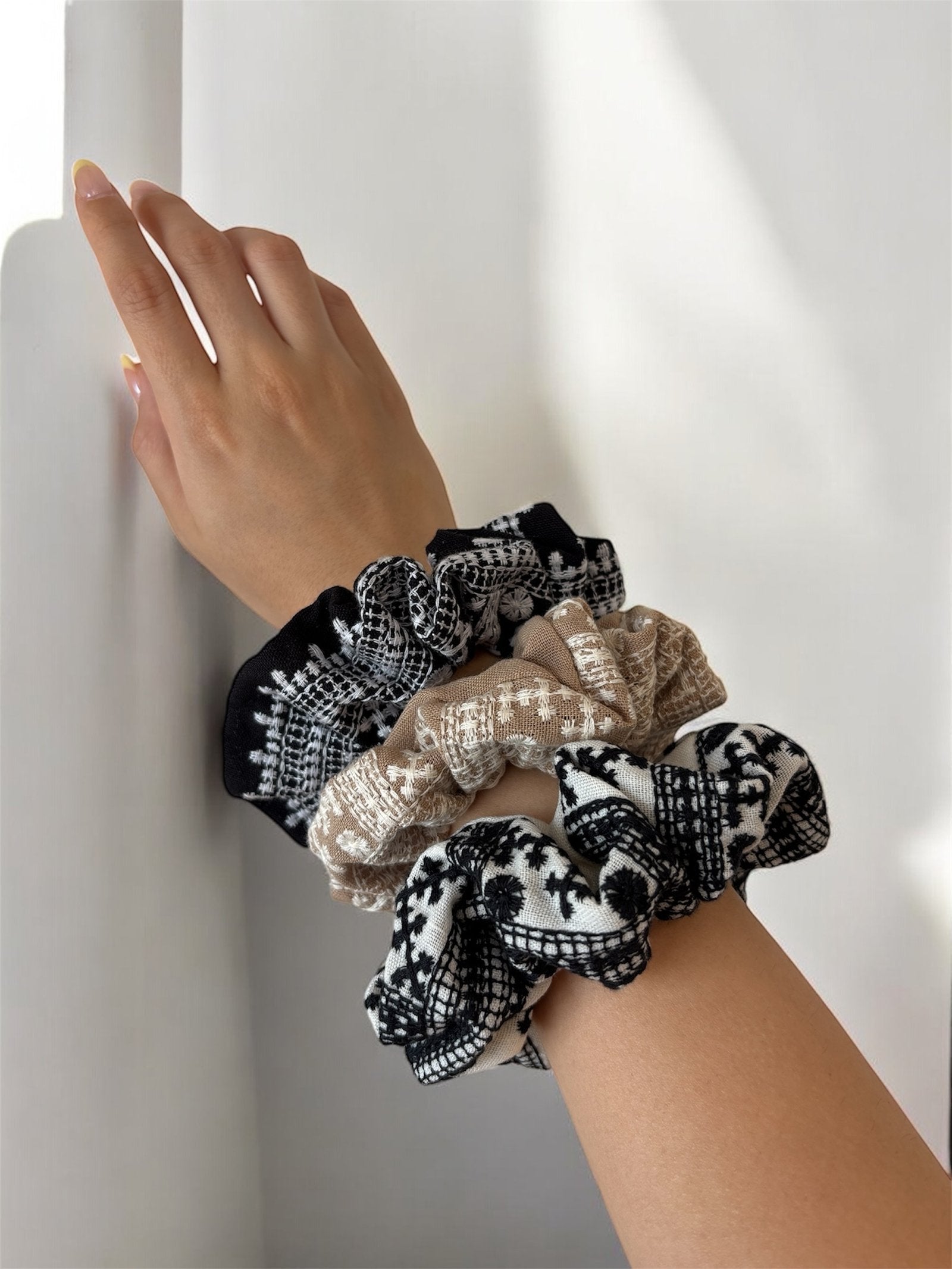 Pulseras scrunchies de tela con motivos geométricos en blanco, negro y beige
