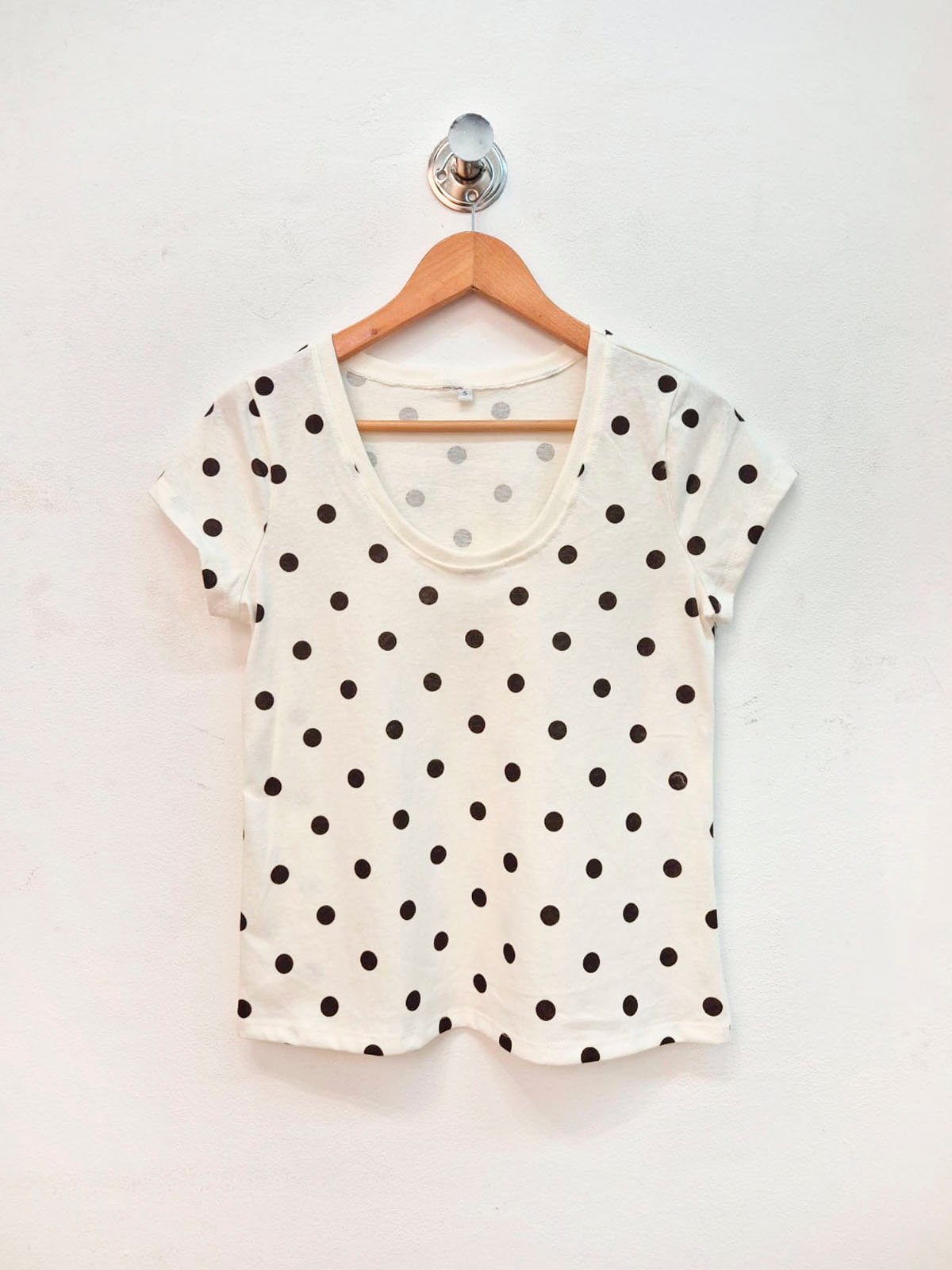 Remera blanca con lunares negros, cuello redondo y manga corta