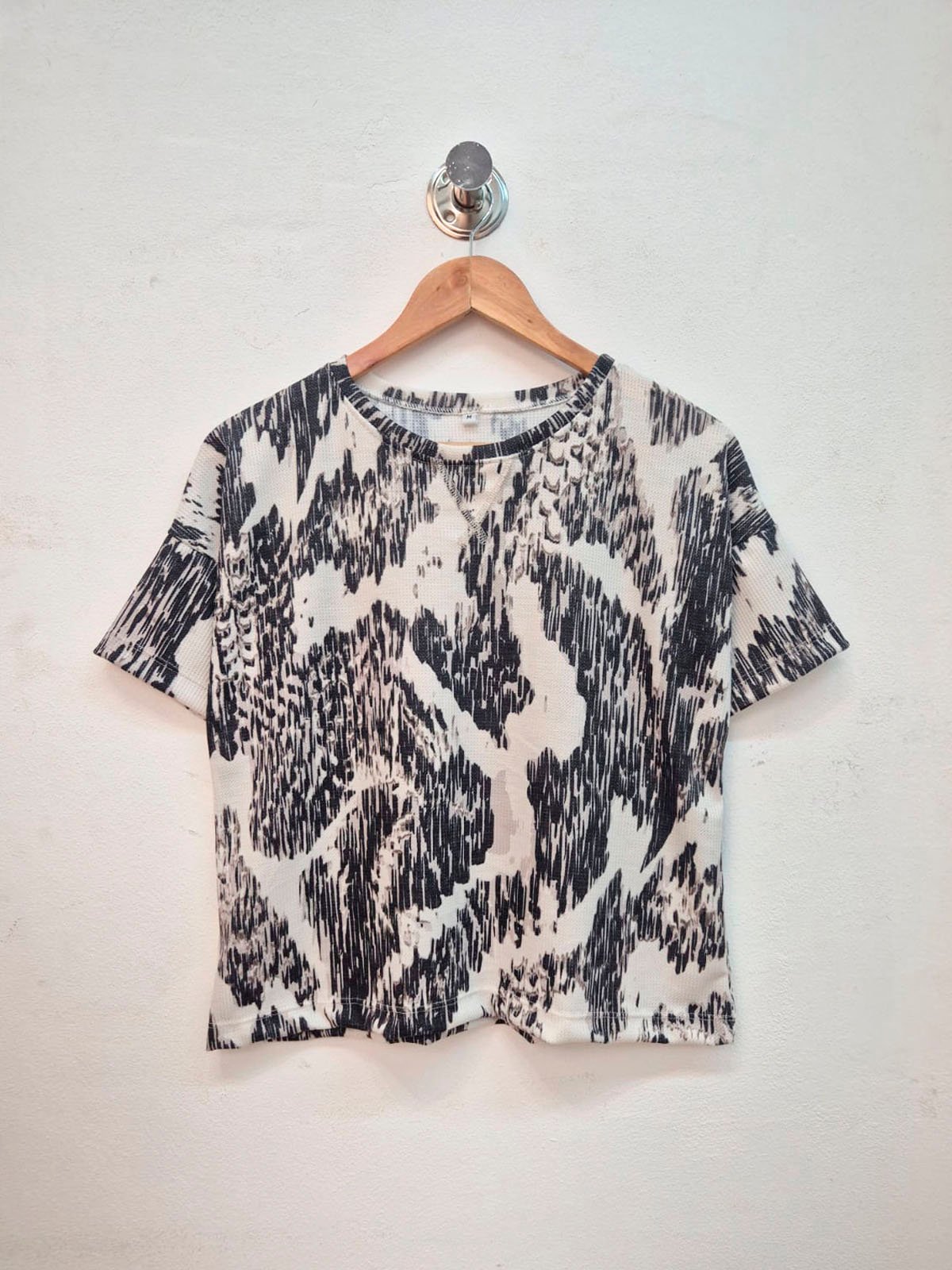 Remera acanalada blanca con estampado animal print negro y manga corta
