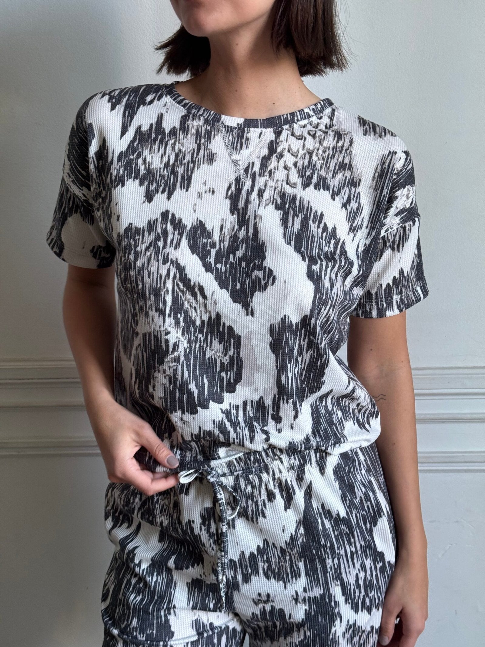 Remera blanca con estampado abstracto negro y manga corta