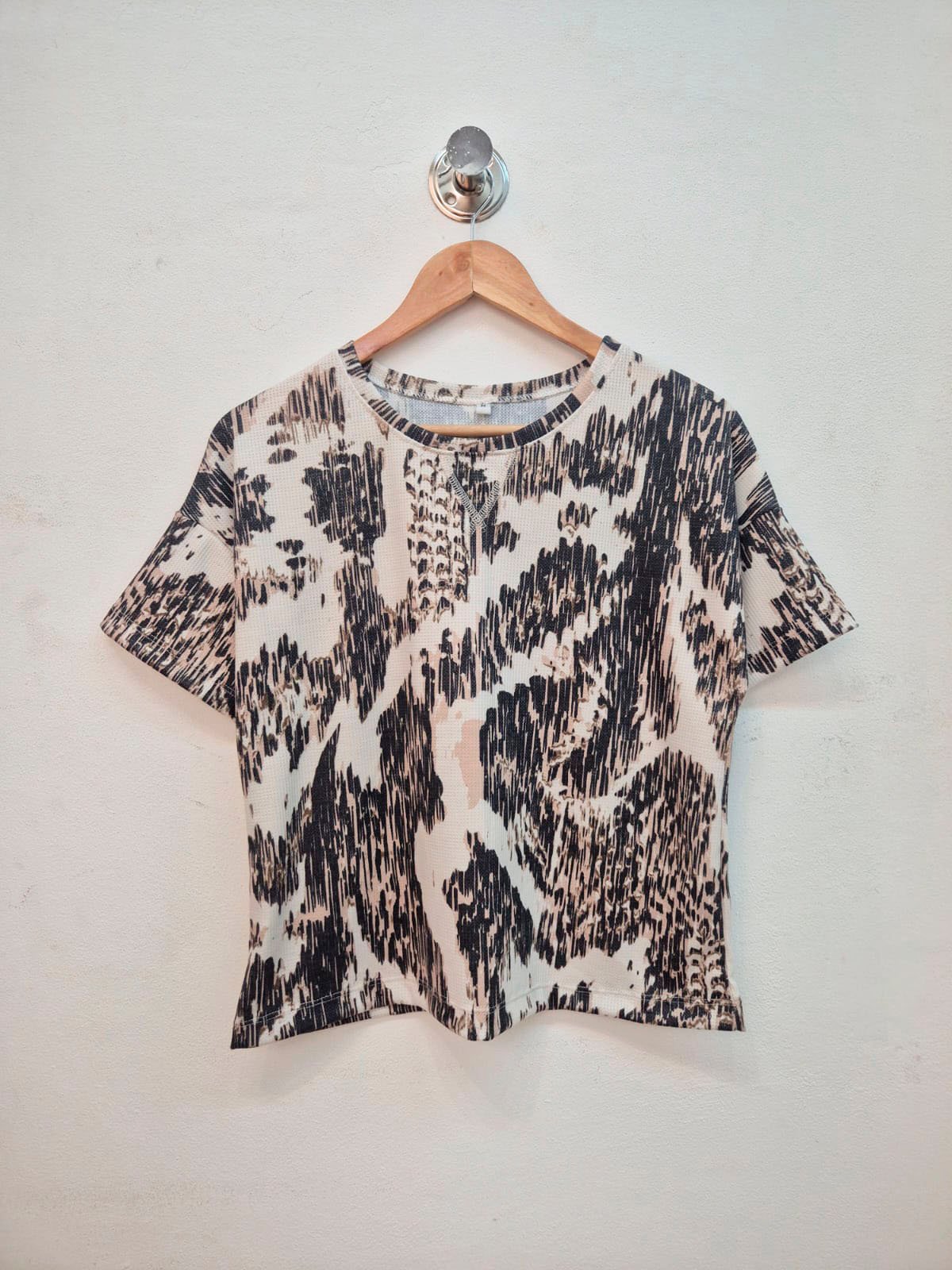 Remera blanca con estampado animal print negro y manga corta