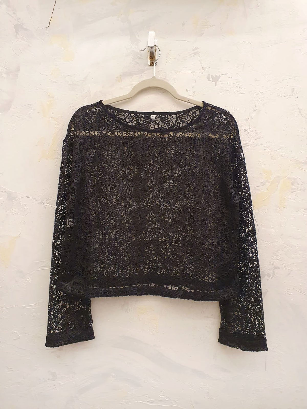 Remera negra de encaje con cuello redondo y manga larga acampanada