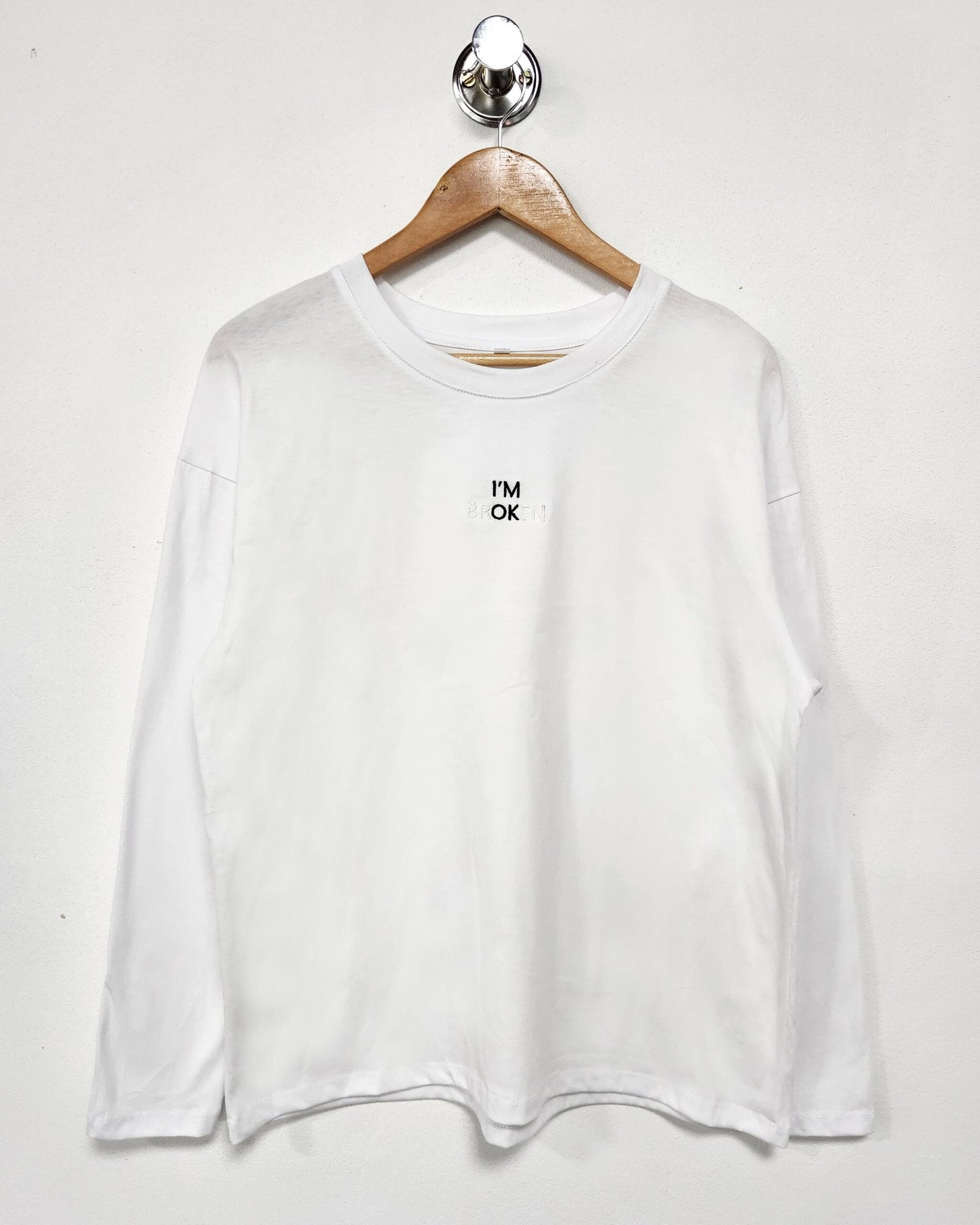Remera blanca de manga larga con estampado de texto pequeño en pecho