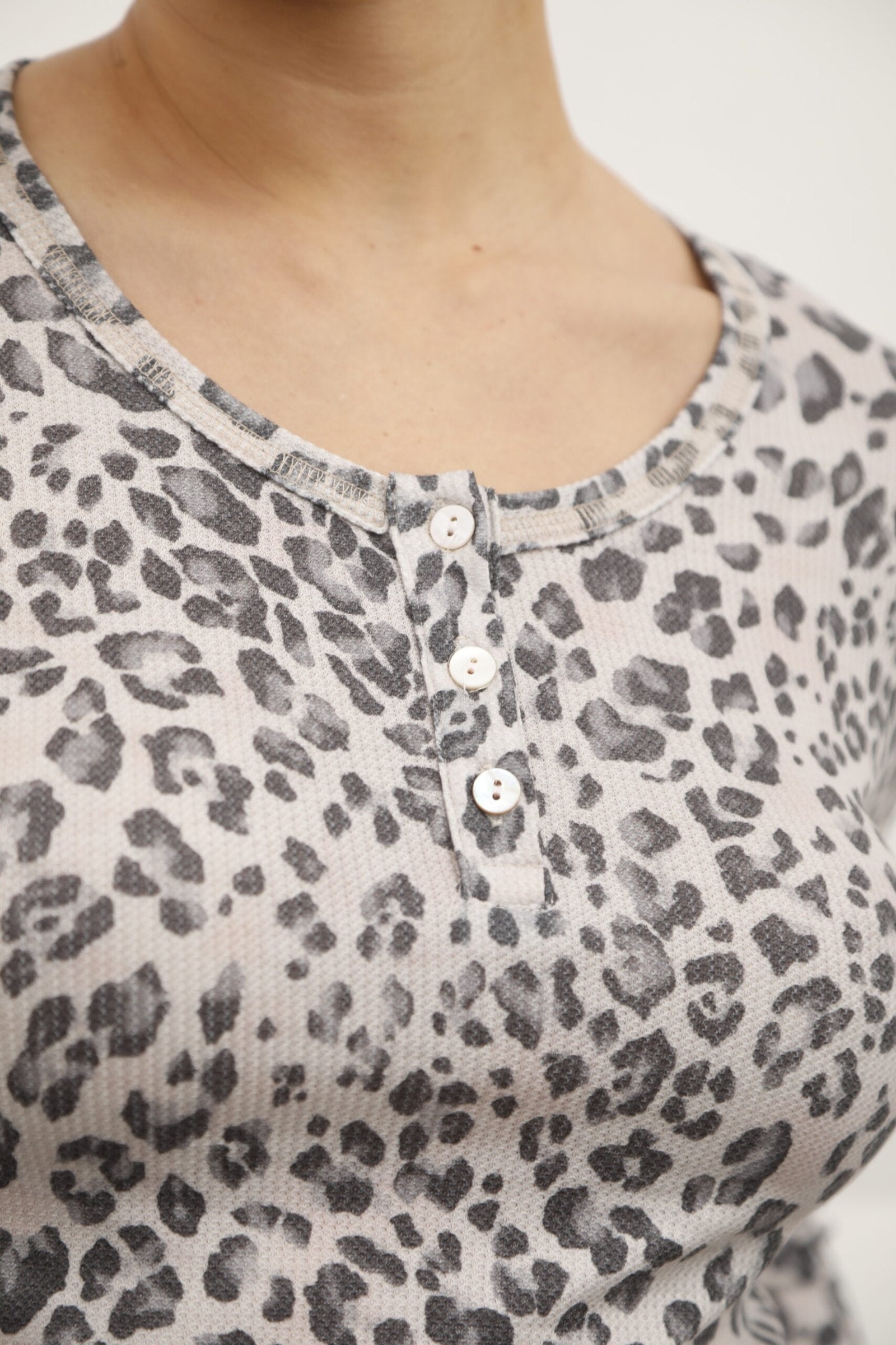 Remera estampado animal print gris con botones en escote redondo