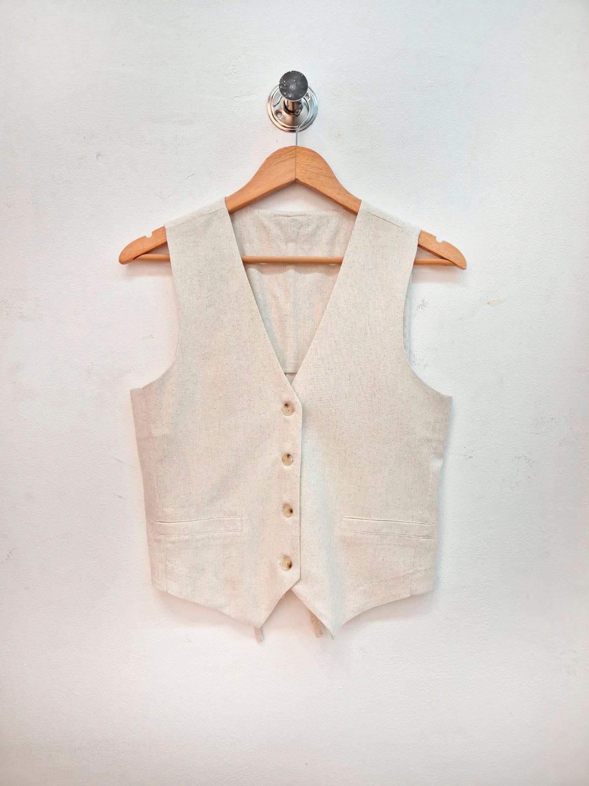 Chaleco beige sin mangas con escote en V y botones frontales