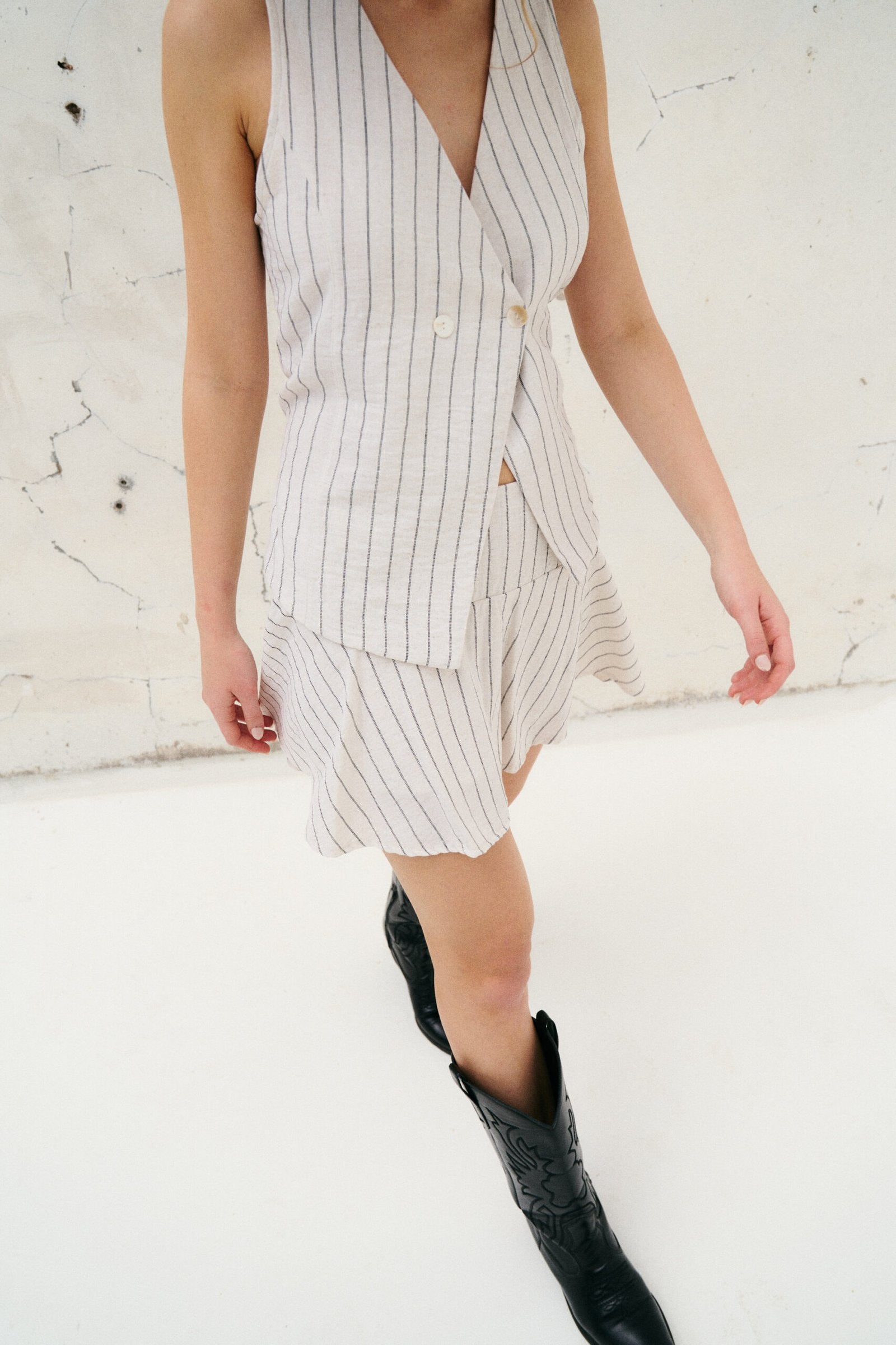 Chaleco blanco con rayas verticales grises y escote en V