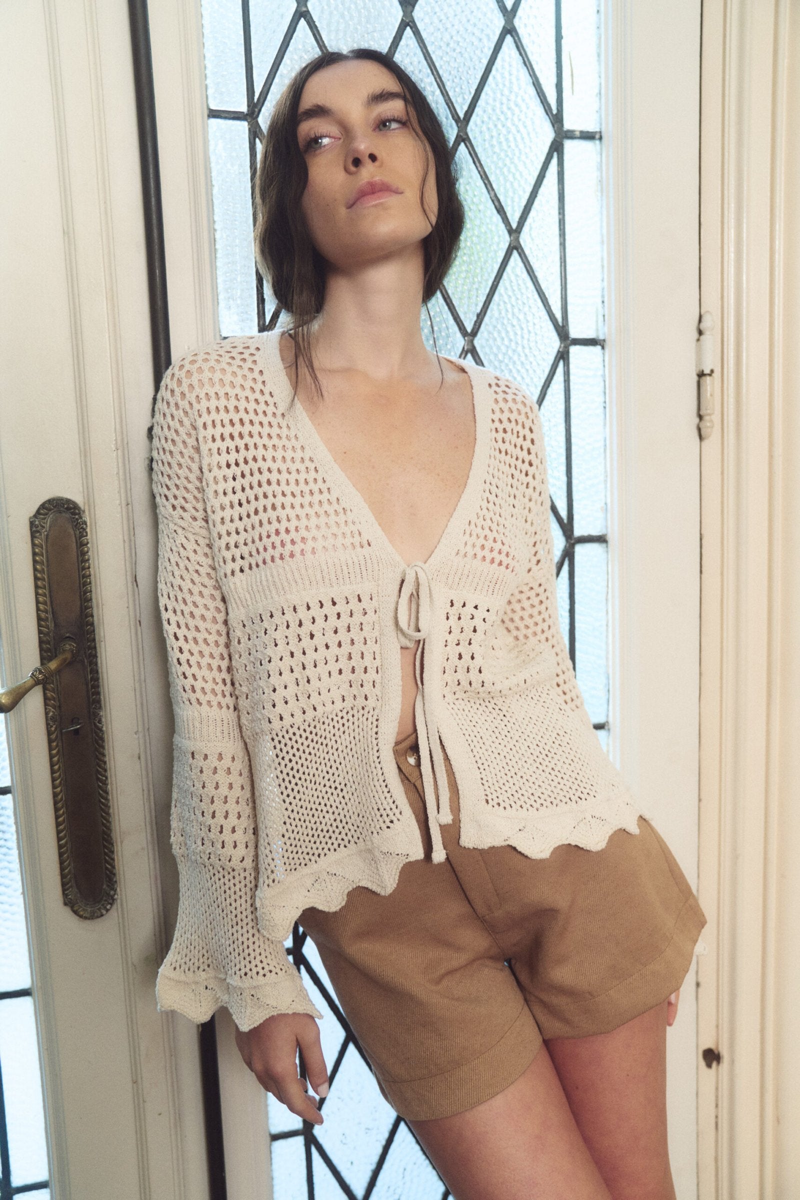 Saquito calado beige con escote V y detalle de anudado delantero