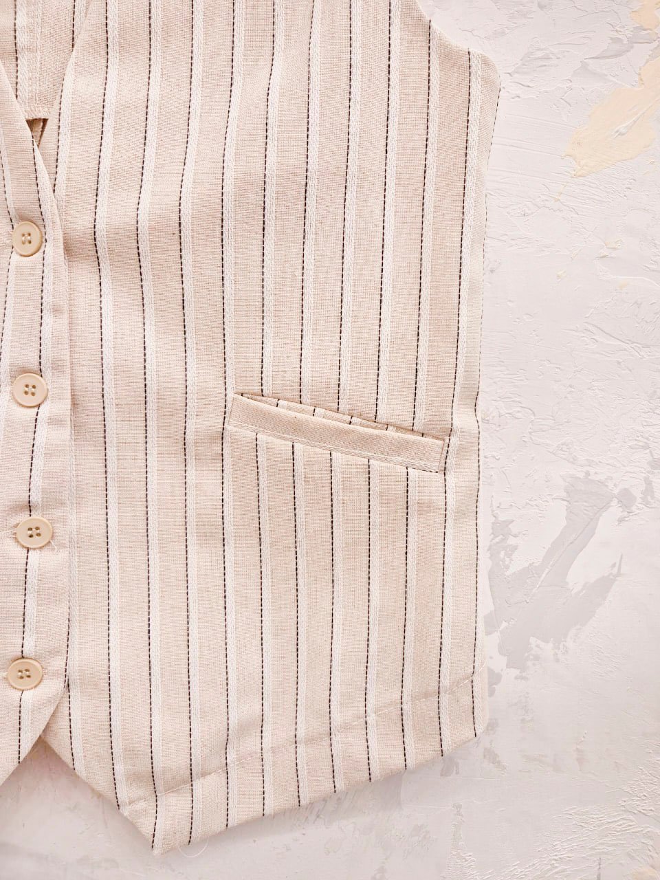 Chaleco beige con rayas verticales marrón y botones frontales