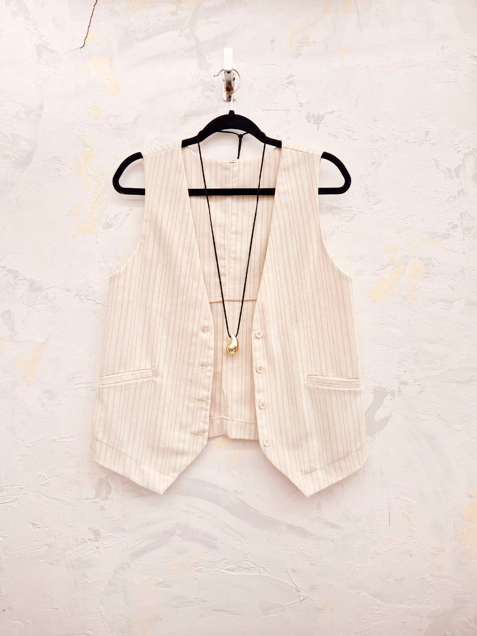 Chaleco beige rayado con botones frontales y bolsillos