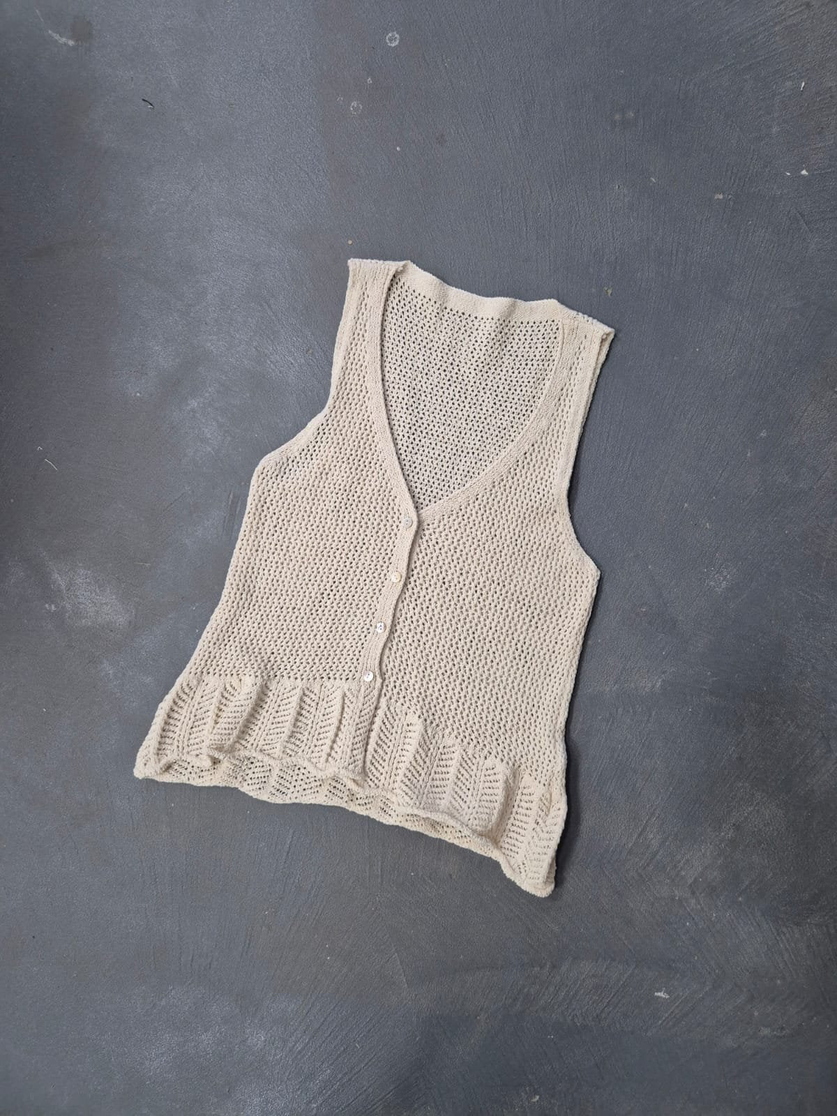 Chaleco beige tejido calado con escote V y volados en ruedo