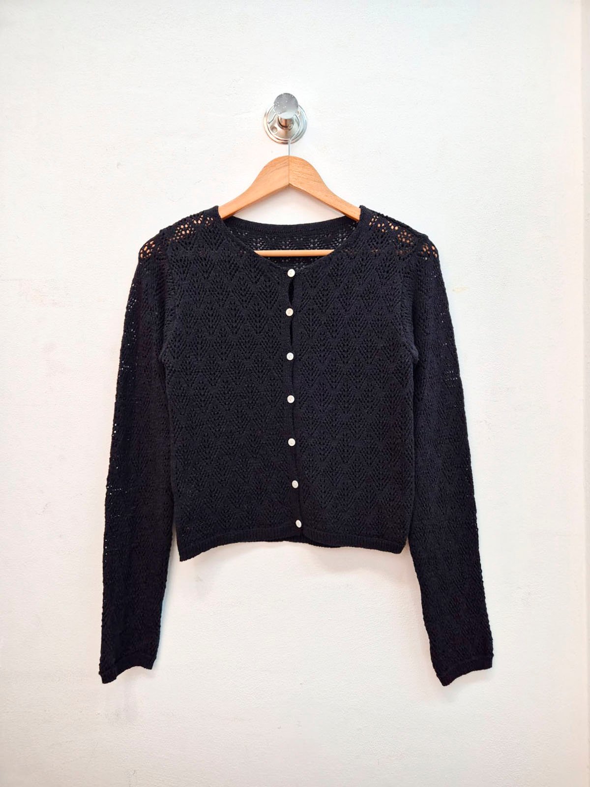 Cardigan negro tejido calado con botones blancos y cuello redondo