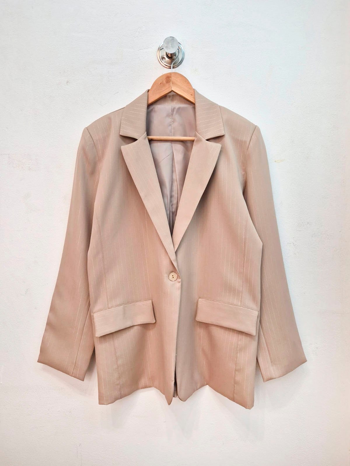 Blazer beige con solapas anchas, manga larga y botón único
