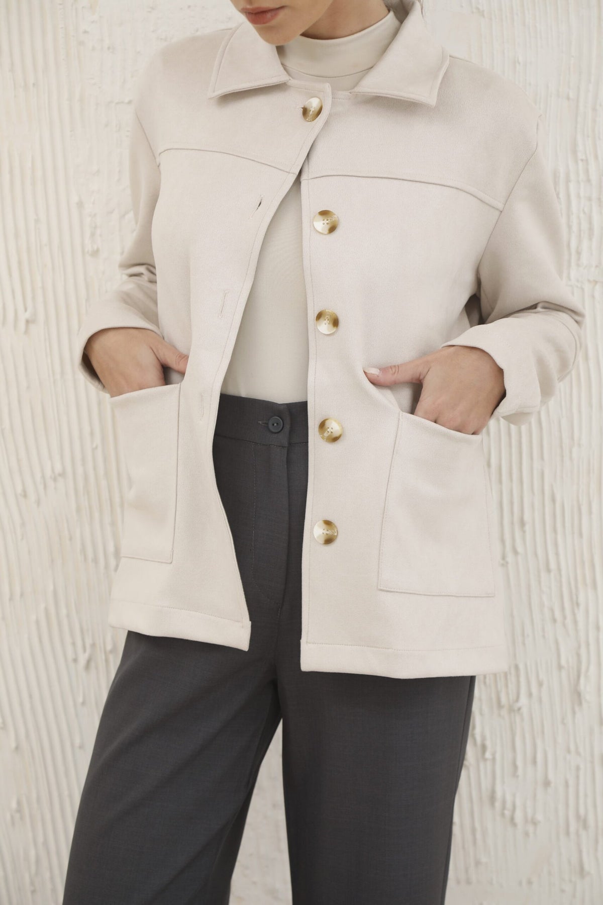 Camisaco beige con botones dorados y bolsillos frontales