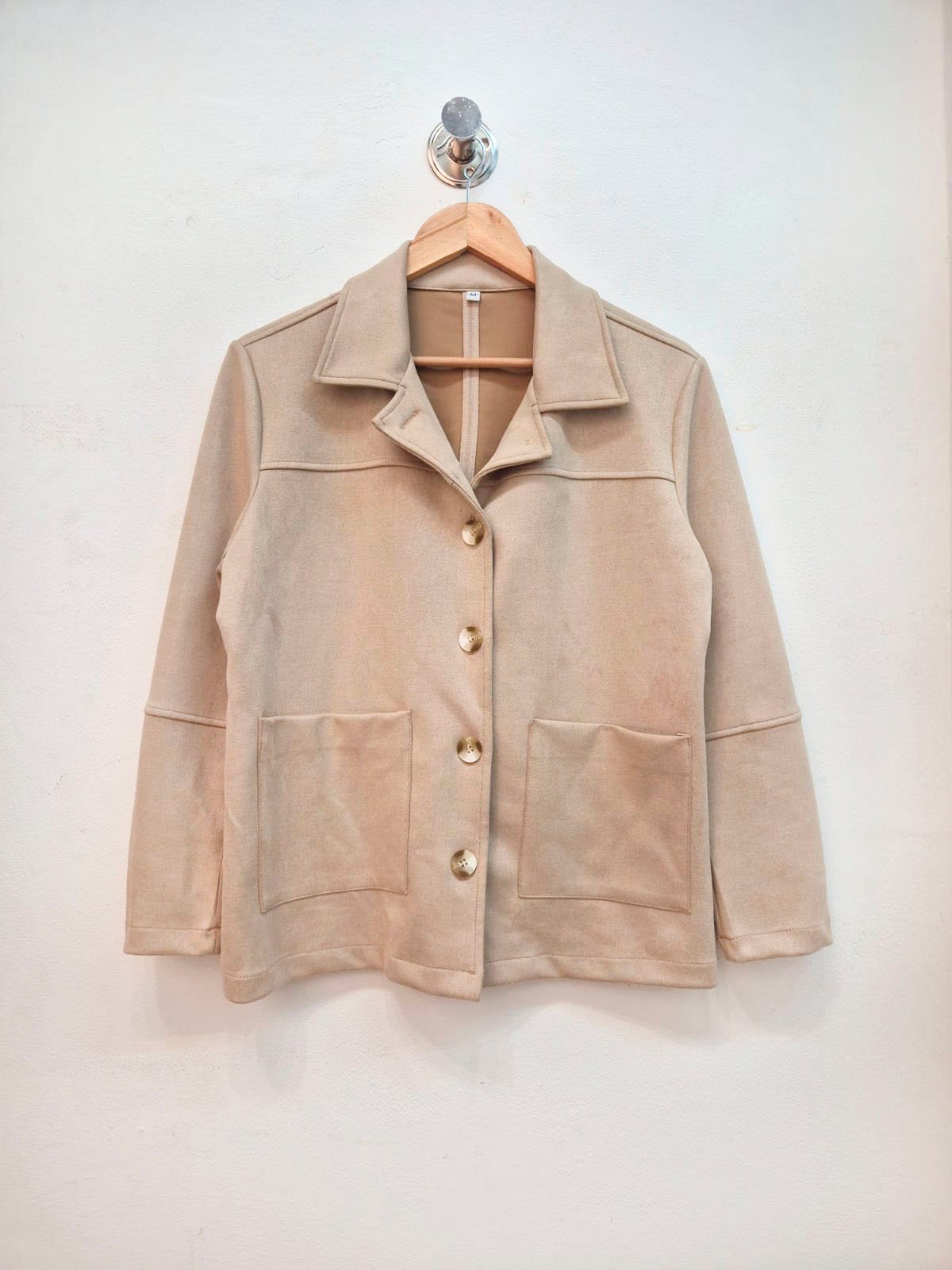 Camisaco beige de manga larga con solapas y bolsillos frontales