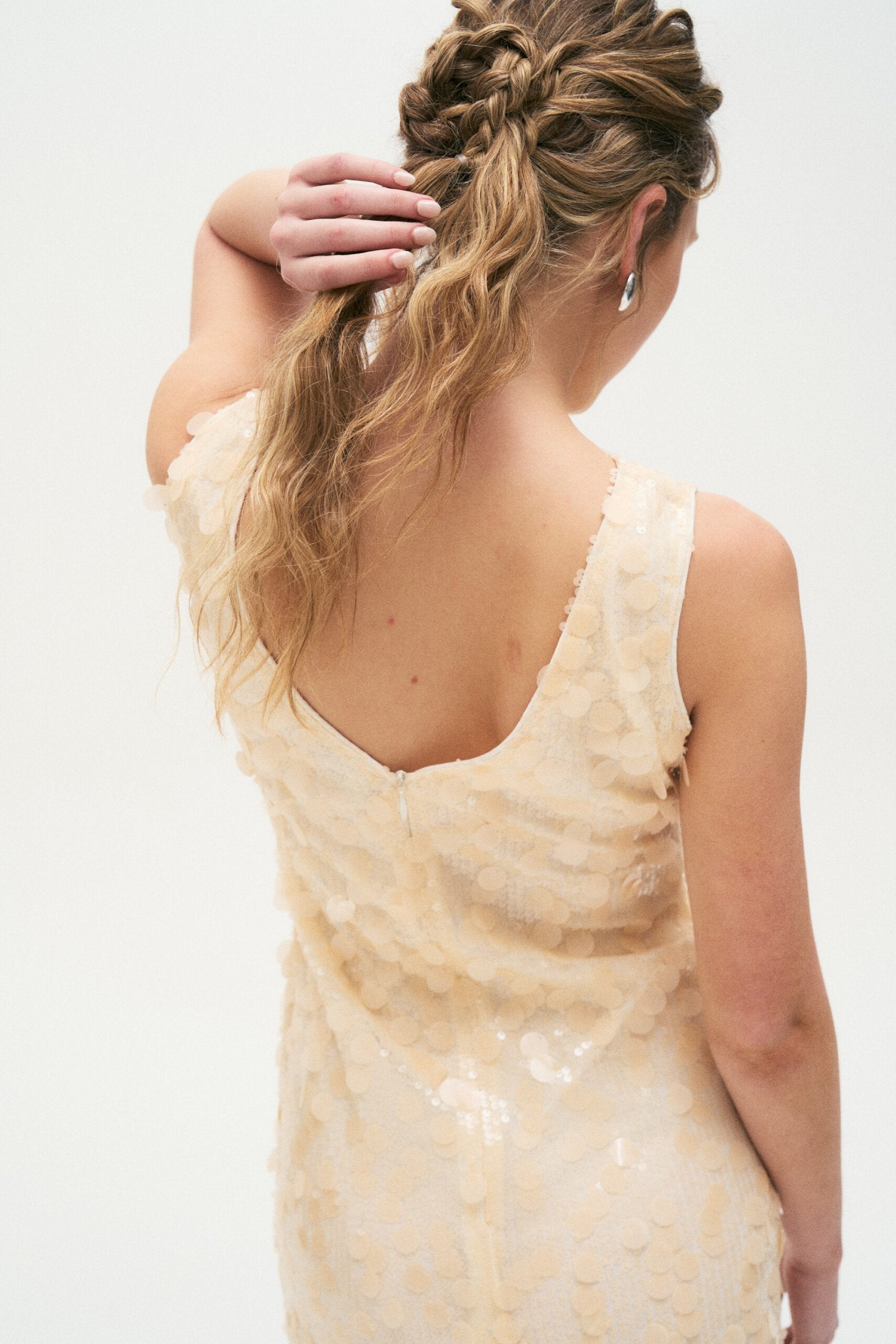 Vestido beige con textura de lentejuelas y escote en V sin mangas