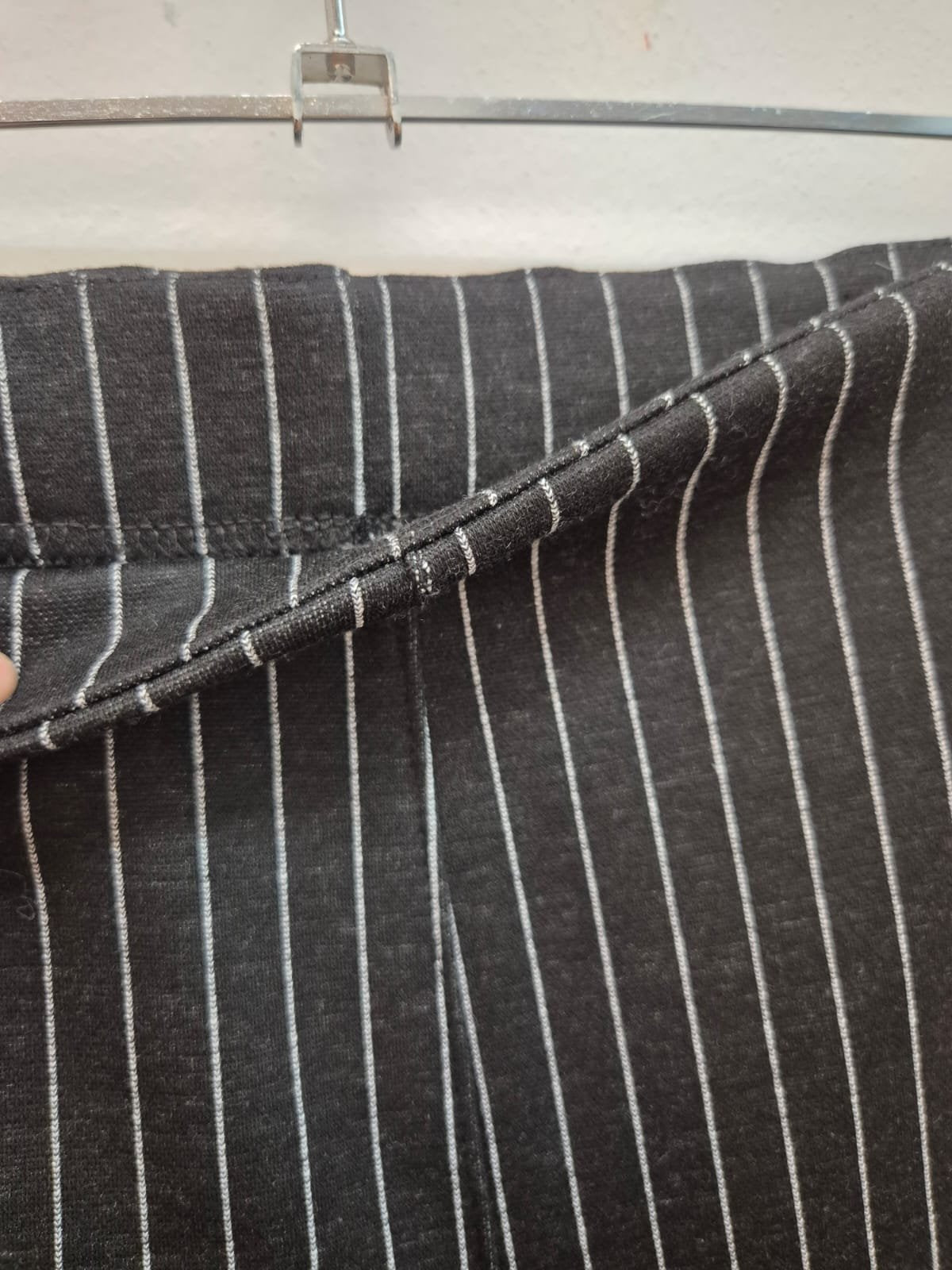 Pantalón gris oscuro a rayas blancas verticales con pinzas