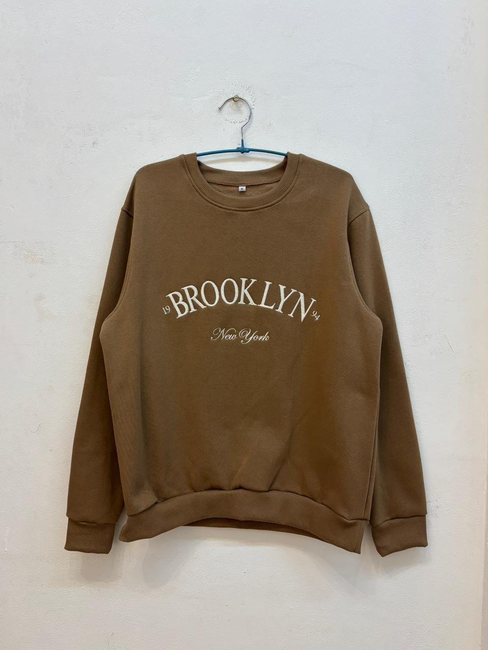 Buzo marrón claro con estampado Brooklyn New York en el frente